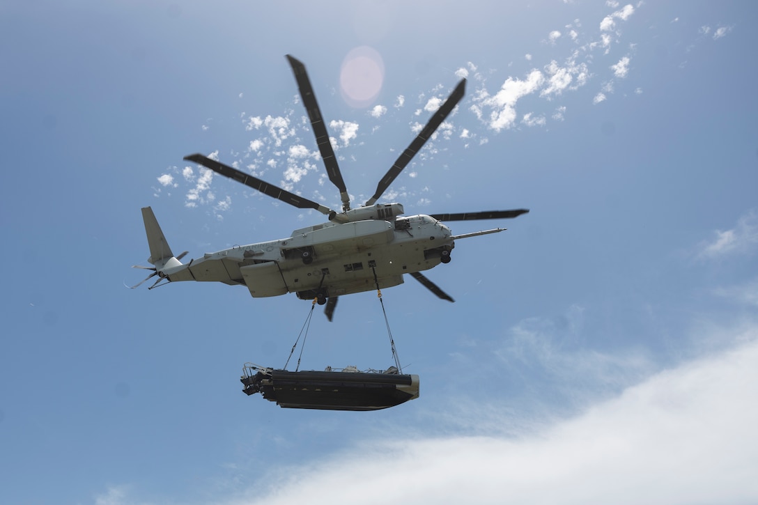 A CH-53K King Stallion with Marine Heavy Helicopter Squadron (HMH) 461, Marine Aircraft Group 29, 2nd Marine Aircraft Wing (MAW), transports a rigid-hull inflatable boat with Charlie Company, 2nd Battalion, U.S. Army Special Warfare Training Group (Airborne) at U.S. Coast Guard base Sector Key West, Florida, July 28, 2025. Marines with 2nd MAW and 2nd Distribution Support Battalion (DSB) are training alongside elements of the U.S. Army, U.S. Navy, and U.S. Customs and Border Protection to refine humanitarian assistance and disaster relief capabilities while also refining the CH-53K’s ability to support distributed aviation operations in a joint environment. (U.S. Marine Corps photo by Cpl. Mya Seymour)