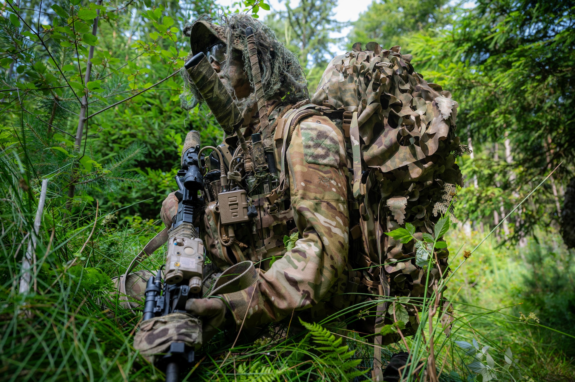 A U.S. Air Force Airman assigned to the 2nd Air Support Operations Squadron provides overwatch as his unit camouflages important supplies during a reconnaissance mission at a training area near Vilseck Army Base, Germany, July 15, 2025.