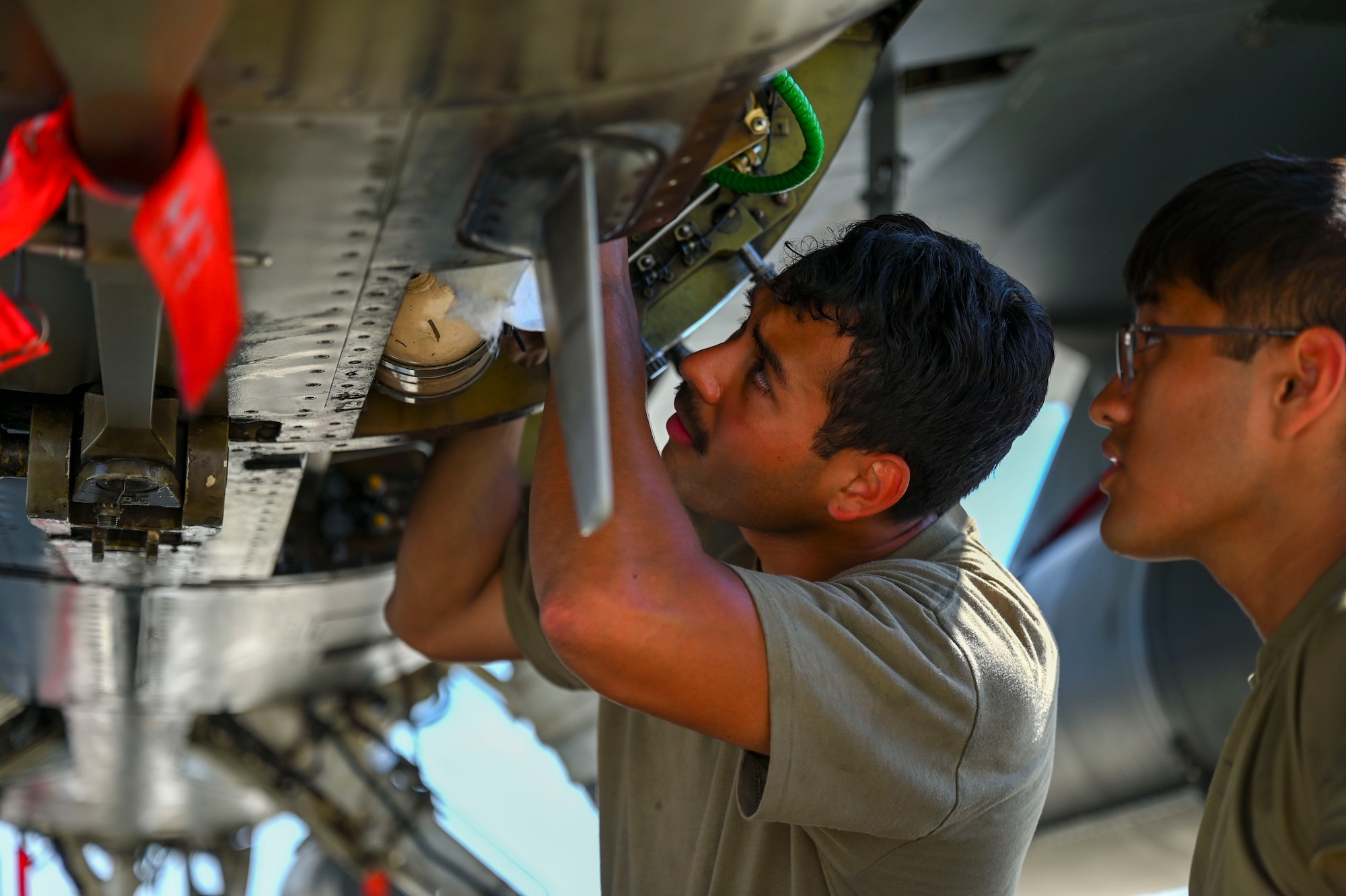 Airmen perform maintenance on a jet.