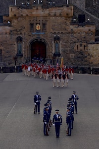 The U.S. Air Force Honor Guard Drill Team finishes their repertoire as the U.S. Army Old Guard Fife and Drum Corps enters the stage during the rehearsal of the 75th Royal Edinburgh Military Tattoo in Edinburgh, Scotland, July 31, 2025.