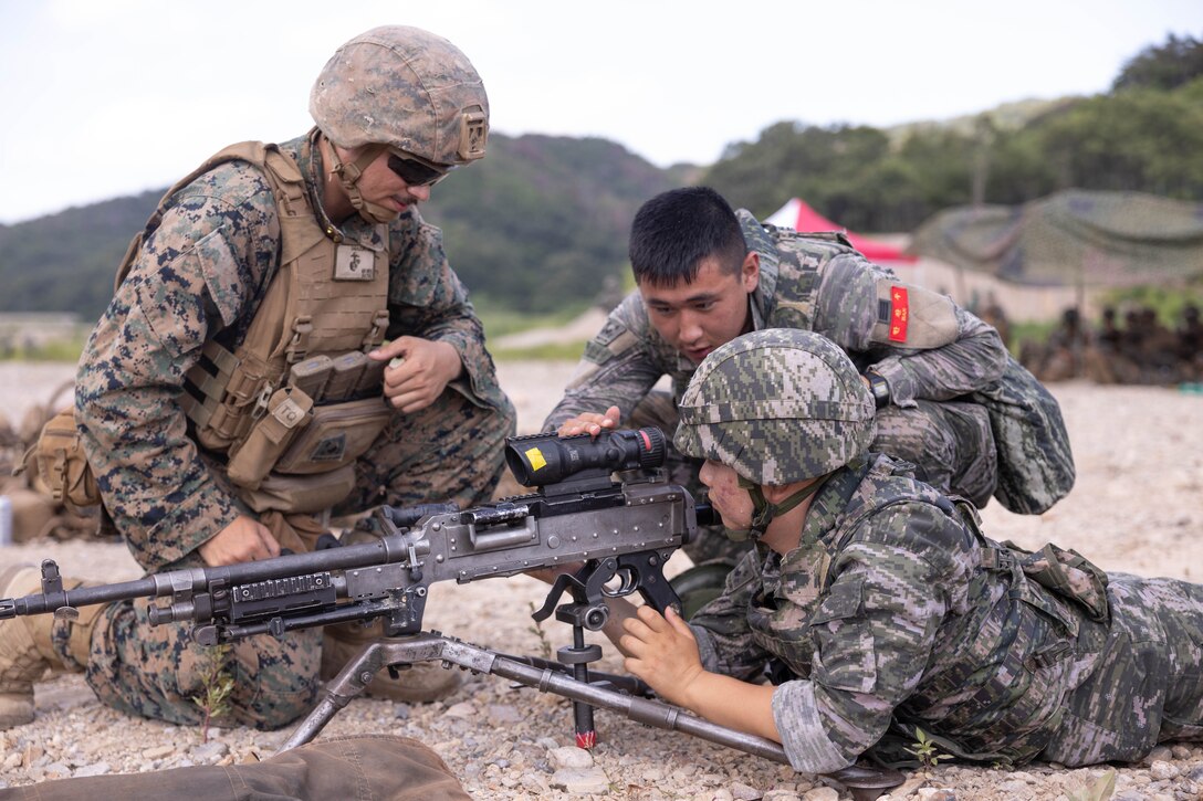 A U.S. Marine with 2nd Battalion, 23rd Marines, forward deployed with 4th Marine Regiment, 3rd Marine Division as part of the Unit Deployment Program, assists Republic of Korea Marines with 1st Marine Division, ROK Marine Corps, in conducting M240B machine gun drills during the Korean Marine Exercise Program 25.2 in Suseong-ri, South Korea, July 30, 2025. KMEP is conducted regularly between the ROK and U.S. Marine Corps to increase their combined capabilities through realistic training geared towards deterrence and maintaining peace in the Indo-Pacific. (U.S. Marine Corps photo by Cpl. Kanoa Thomas)