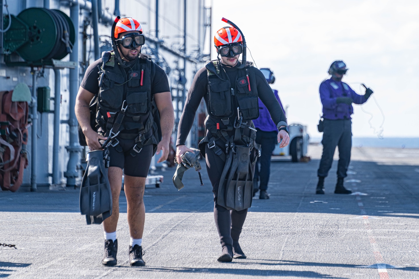 Naval Aircrewman (Helicopter) 3rd Class Zachary Santos, left, from Brockton, Massachusetts, and Naval Aircrewman (Helicopter) 2nd Class Ethan Kubat, right, from Lincoln, Illinois, assigned to Helicopter Sea Combat Squadron (HSC) 25 walk across the flight deck of the forward-deployed amphibious assault ship USS America (LHA 6), while conducting flight operations in the Philippine Sea, Feb. 27. America, lead ship of the America Amphibious Ready Group, is operating in the U.S. 7th Fleet area of operations. U.S. 7th Fleet is the U.S. Navy’s largest forward-deployed numbered fleet, and routinely interacts and operates with allies and partners in preserving a free and open Indo-Pacific region.