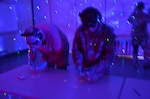 Maj. Carolina Wentworth (right), METC Army Dental Specialist Course Director, attempts to perform an individual task under impaired conditions while participating in the Dementia Experience. The Dementia Experience is an innovative, immersive dementia simulation that allow participants to personally experience the daily challenges that cognitively impaired people face.