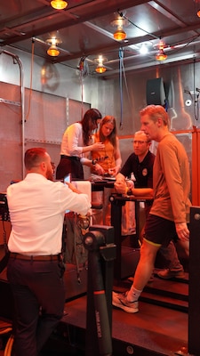 SAN DIEGO (April 17, 2024) National Public Radio’s (NPR) Marketplace host Kai Ryssdal performs the task of walking on a treadmill for 25 minutes inside the Naval Health Research Center Warfighter Performance Laboratory’s environmental chamber. During this 25 minute test, Ryssdal was joined by Dr. Dough Jones and Dr. Tim Dunn of NHRC, who assessed Ryssdal’s cognitive functions while his physiological responses were recorded. This exercise was recorded for an episode of NPR’s podcast series, “How We Survive.”  NHRC, part of Navy Medicine Research & Development, supports Navy, Marine Corps, and joint U.S. warfighter health readiness and lethality with research and development that delivers high-value, high-impact solutions to the health and readiness challenges U.S. military population faces on the battlefield, at-sea, home and abroad. (U.S. Navy photo by Danielle Cazarez/released)