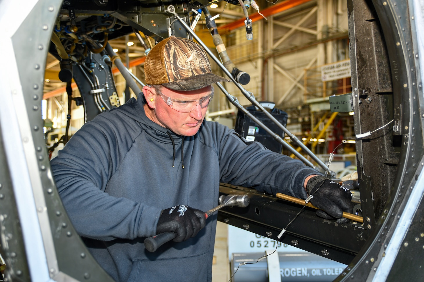 Chris Willis, a V-22 aircraft mechanic at Fleet Readiness Center East (FRCE), performs maintenance on a V-22 Osprey inside the depot’s hangar while utilizing the appropriate personal protective equipment. FRCE recently earned the Chief of Naval Operations (CNO) Shore Safety Award in the Large Industrial Activity category for the second consecutive year for its continued efforts toward safety and occupational health excellence in fiscal year 2024.