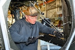 Chris Willis, a V-22 aircraft mechanic at Fleet Readiness Center East (FRCE), performs maintenance on a V-22 Osprey inside the depot’s hangar while utilizing the appropriate personal protective equipment. FRCE recently earned the Chief of Naval Operations (CNO) Shore Safety Award in the Large Industrial Activity category for the second consecutive year for its continued efforts toward safety and occupational health excellence in fiscal year 2024.