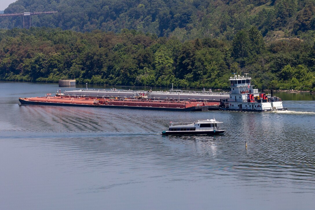 A small boat passes by a barge on a river.