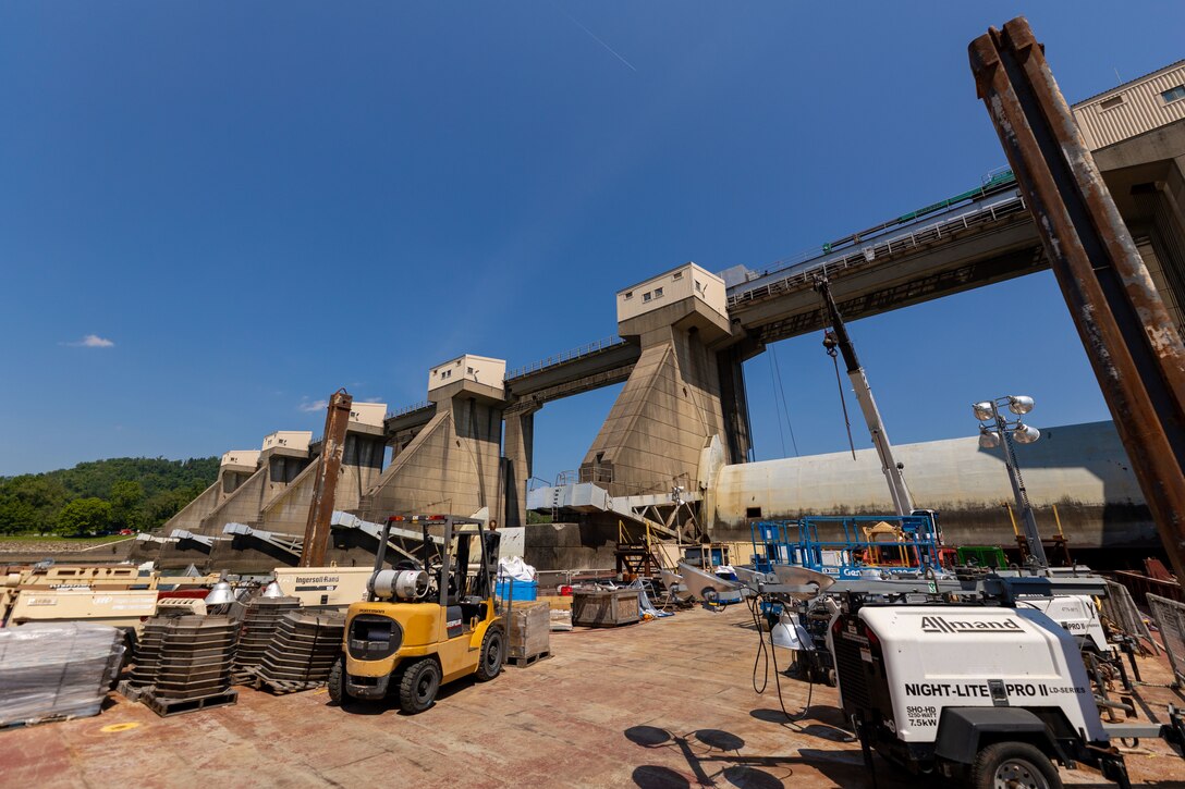 Construction equipment sits on a working barge at a river lock.
