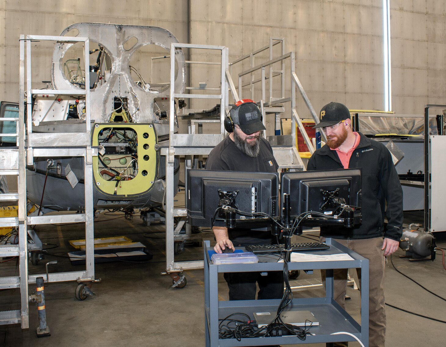 Chris Smith, left, airframes mechanic, and Todd Baker, right, H-1 production supervisor, access the electronic work order (EWO) system at the Fleet Readiness Center East (FRCE) detachment onboard Marine Corps Air Station Cherry Point in Jacksonville, North Carolina.