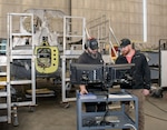 Chris Smith, left, airframes mechanic, and Todd Baker, right, H-1 production supervisor, access the electronic work order (EWO) system at the Fleet Readiness Center East (FRCE) detachment onboard Marine Corps Air Station Cherry Point in Jacksonville, North Carolina.