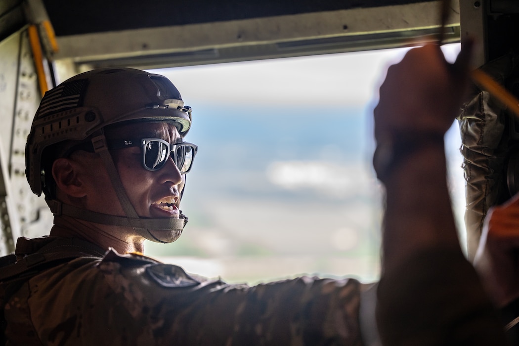 A man, wearing sunglasses and military helmet with mouth open is shouting