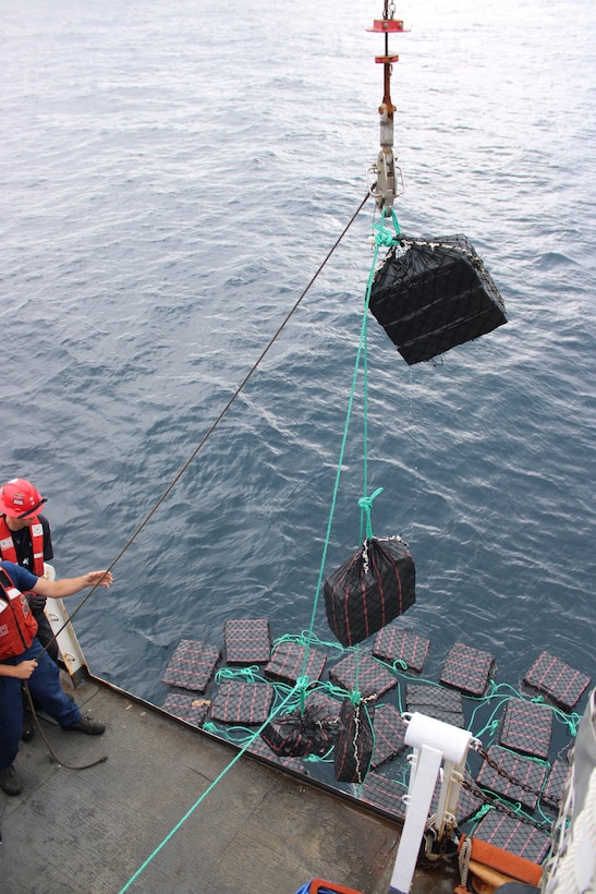 Crew members aboard the U.S. Coast Guard Escanaba (WMEC 907) hoisting bales of cocaine in the eastern Pacific. The drugs were offloaded at Port Everglades, Florida, August 5, 2025. (U.S. Coast Guard photo)
