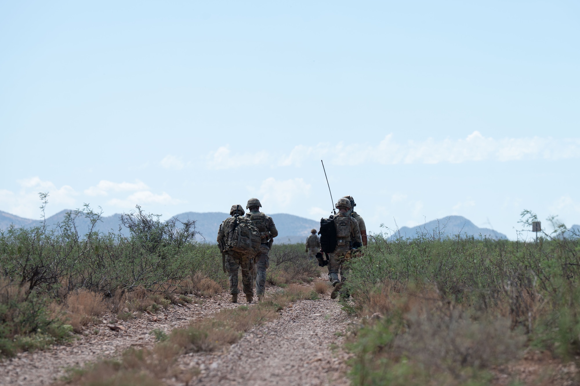 U.S. Airmen assigned to 14th Air Support Operation Squadron and U.S. Army soldiers with 2nd Battalion, 12th Infantry Regiment, 2nd Brigade Combat Team, 4th Infantry Division, walk back to base after a successful exercise in Pearce, Arizona, July 31, 2025. Air Force joint terminal attack controllers and Army personnel conducted joint training to develop and improve air-to-ground integration in a simulated contested environment and enhanced joint and total force operational readiness. (U.S. Air Force photo by Airman Jaden Kidd)