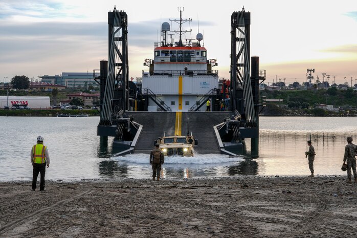 A Joint Light Tactical Vehicle drives off of the ramp of a Stern Landing Vessel, a modified oil-rig industry off-shore support vessel, in order to transport personnel off of the vessel as part of Project Convergence Capstone Four, Feb. 23, 2024 at the Del Mar Boat Basin, Camp Pendleton, CA. The Marine Corps Warfighting Laboratory contracted the SLV to experiment with maneuver and sustainment options for Stand-In Forces to inform the development of the Medium Landing Ship (LSM). PC-C4 is an Army-hosted, all-Service and multinational experiment. During PC-C4, the Marine Corps Warfighting Laboratory tested new technologies and capabilities and emerging concepts, including the multi-domain corridor. Marine Corps participation in PC-C4 supported Force Design initiatives, integrated Joint force and coalition capabilities into experimentation, and demonstrated the Marine Corps' commitment to the Joint Warfighting Concept. (U.S. Marine Corps photo by Kevin Ray J. Salvador)