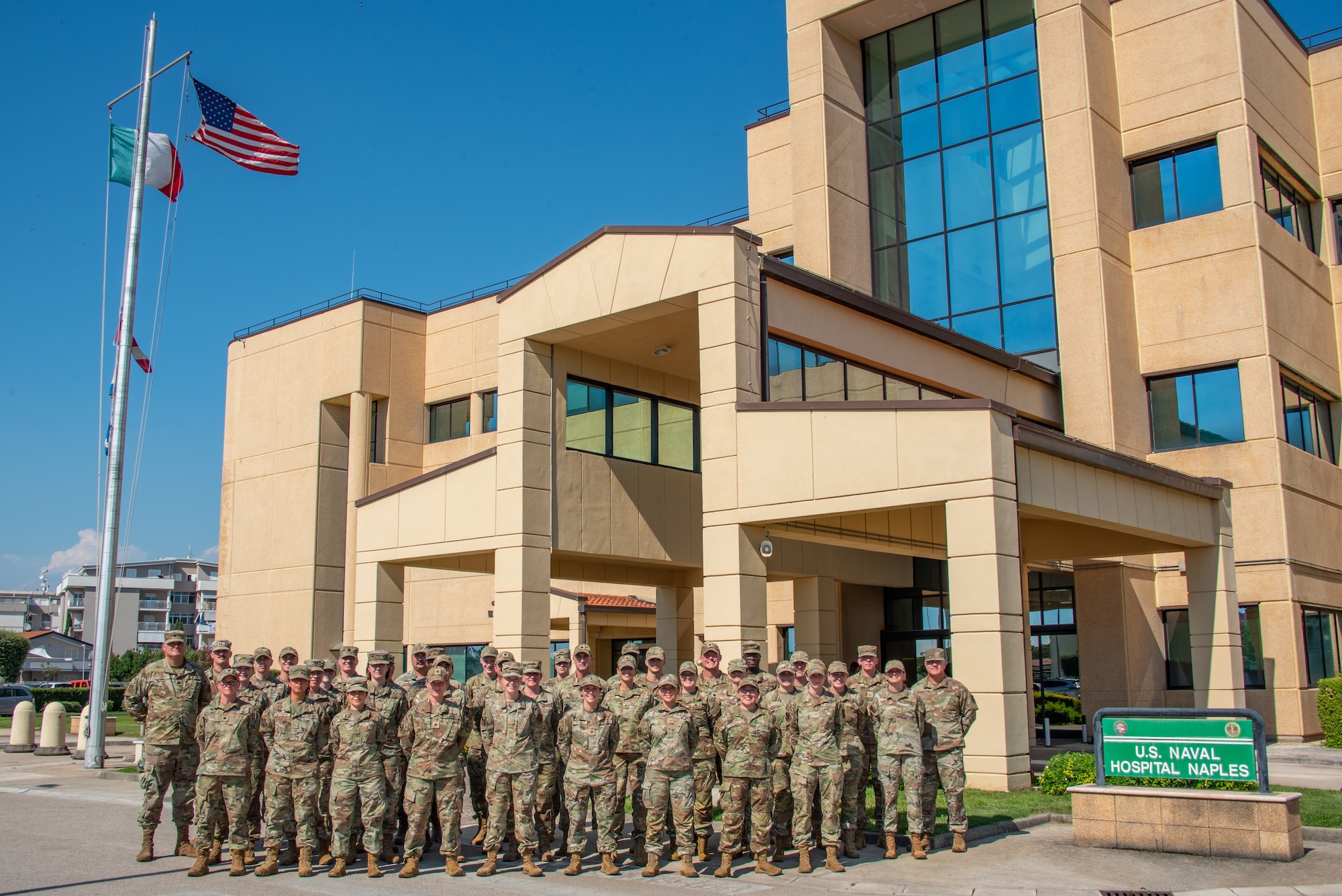 A group of 134th Medical Group Airmen stand in front of the U.S. Naval Hospital Naples.