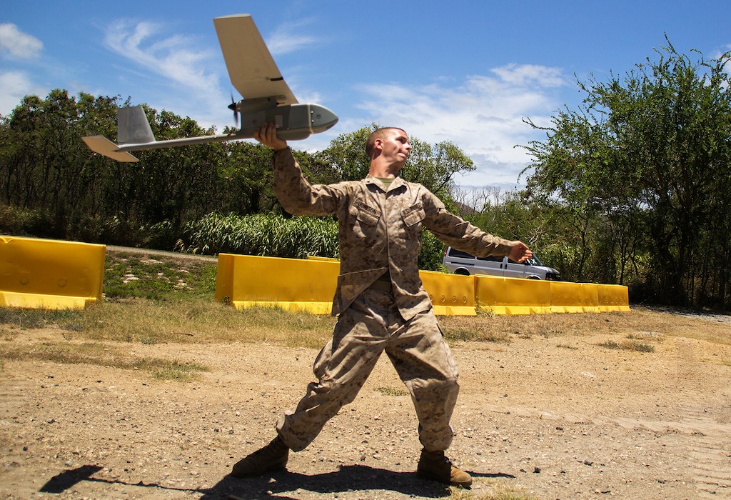 MARINE CORPS TRAINING AREA BELLOWS, Hawaii - Lance Cpl. Levi Johnson, an intelligence specialist with Headquarters Battery, 1st Battalion, 12th Marine Regiment, and a 20-year-old native of Springdale, Ark., launches the Unmanned Aircraft System (UAS) Raven drone to provide overwatch of friendly and enemy forces in the area at Marine Corps Training Area Bellows, July 12, 2014. The UAS is a lightweight drone that can fly at a range of five-to-ten kilometers and stay in the air for up 90 minutes. The UAS is part of the Marine Corps Advanced Warfighting Experiment, a culmination of progressive experiments designed to test potential future technologies, solutions and concepts to future Marine Air Ground Task Force challenges being led by the Marine Corps Warfighting Lab (MCWL). (U.S. Marine Corps photo by Cpl. Matthew J. Bragg)