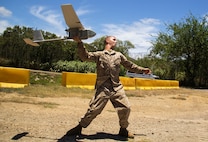 MARINE CORPS TRAINING AREA BELLOWS, Hawaii - Lance Cpl. Levi Johnson, an intelligence specialist with Headquarters Battery, 1st Battalion, 12th Marine Regiment, and a 20-year-old native of Springdale, Ark., launches the Unmanned Aircraft System (UAS) Raven drone to provide overwatch of friendly and enemy forces in the area at Marine Corps Training Area Bellows, July 12, 2014. The UAS is a lightweight drone that can fly at a range of five-to-ten kilometers and stay in the air for up 90 minutes. The UAS is part of the Marine Corps Advanced Warfighting Experiment, a culmination of progressive experiments designed to test potential future technologies, solutions and concepts to future Marine Air Ground Task Force challenges being led by the Marine Corps Warfighting Lab (MCWL). (U.S. Marine Corps photo by Cpl. Matthew J. Bragg)