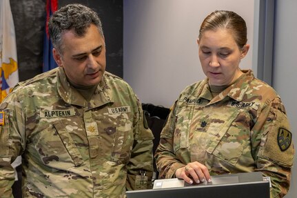 Maj. Cihan Alptekin, U.S. Army Finance and Comptroller School proponency officer, and Lt. Col. Pampuch-Borden, U.S. Army Financial Management Command reserve component finance and comptroller senior advisor, discuss operations during a staff exercise at the Maj. Gen. Emmett J. Bean Federal Center in Indianapolis Oct. 31, 2024. USAFMCOM hosted the exercise to increase its operational capabilities through the four phases of the conflict continuum, reduce its inefficiencies in battle tasks, and clearly identify financial management roles, responsibilities and authorities. (U.S. Army photo by Mark R. W. Orders-Woempner)