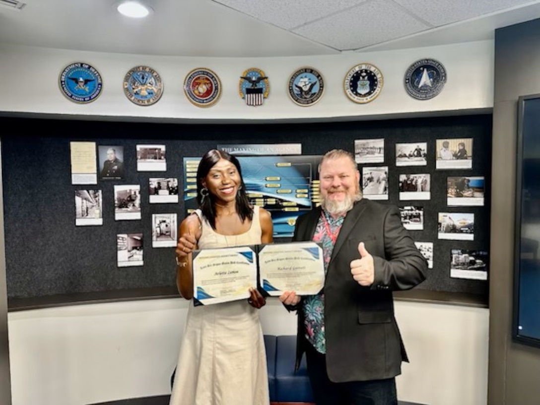 Two people holding certificates