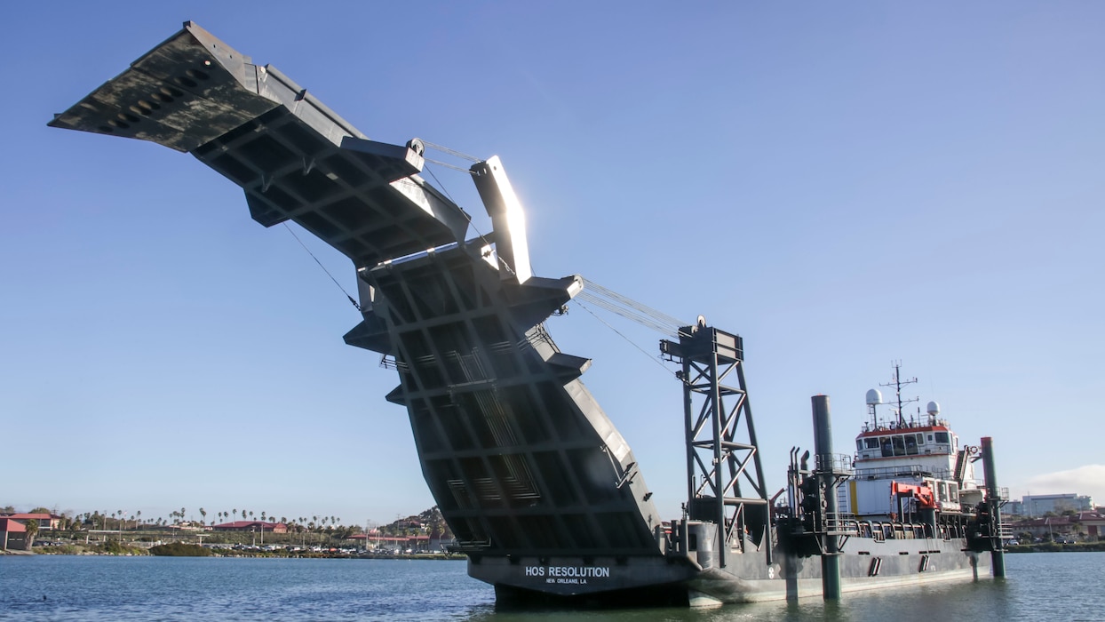 A Stern Landing Vessel, a modified oil-rig industry off-shore support vessel, prepares to drop its ramp onto the beach in order to load cargo as part of Project Convergence Capstone 4, Feb. 22, 2024 at the Del Mar Boat Basin, Camp Pendleton, CA. The Marine Corps Warfighting Laboratory contracted the SLV to experiment with maneuver and sustainment options for Stand-In Forces to inform the development of the Medium Landing Ship (LSM). PC-C4 is an Army-hosted, all-Service and multinational experiment. During PC-C4, the Marine Corps Warfighting Laboratory tested new technologies and capabilities and emerging concepts, including the multi-domain corridor. Marine Corps participation in PC-C4 supported Force Design initiatives, integrated Joint force and coalition capabilities into experimentation, and demonstrated the Marine Corps' commitment to the Joint Warfighting Concept. (U.S. Marine Corps photo by Kevin Ray J. Salvador)