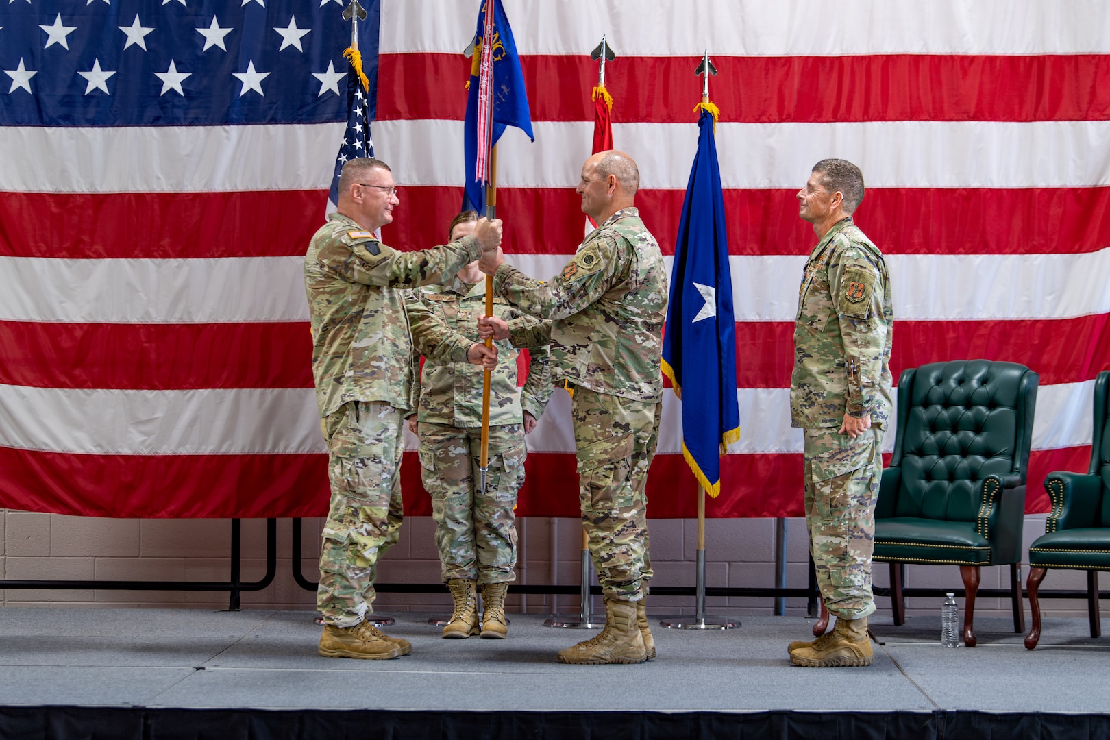 U.S. Army Maj. Gen. Gregory Knight, the adjutant general of Vermont, presents the guidon of the Vermont Air National Guard to U.S. Air Force Brig. Gen. David Shevchik Jr.