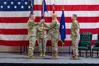 U.S. Army Maj. Gen. Gregory Knight, the adjutant general of Vermont, presents the guidon of the Vermont Air National Guard to U.S. Air Force Brig. Gen. David Shevchik Jr.