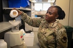 Service member pours pills into a pill counter machine