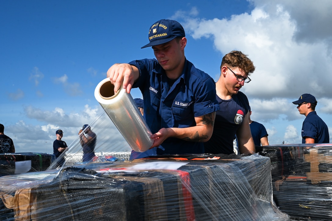 Seaman Conway wrapping a pallet of interdicted narcotics on the flight deck of the U.S. Coast Guard Cutter Escanaba at Port Everglades, Florida, August 5, 2025.Interdictions in the Eastern Pacific Ocean are performed by members of the U.S. Coast Guard under the authority and control of the Southwest Coast Guard District, headquartered in Alameda, California. (U.S. Coast Guard photo by Petty Officer 3rd Class Jessica Walker)