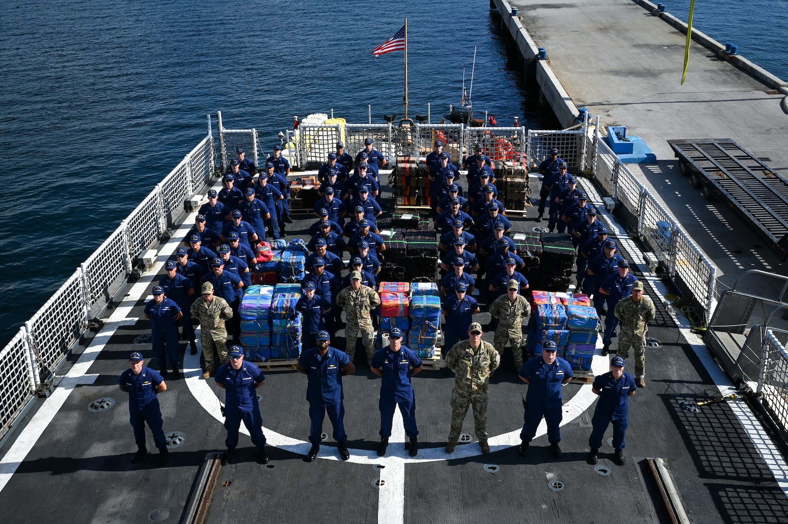 The crew of the U.S. Coast Guard Cutter Escanaba standing at parade rest on the flight deck at Port Everglades, Florida, August 5, 2025. The seized contraband was transferred to partner agencies for accountability and destruction. (U.S. Coast Guard photo by Petty Officer 3rd Class Jessica Walker)