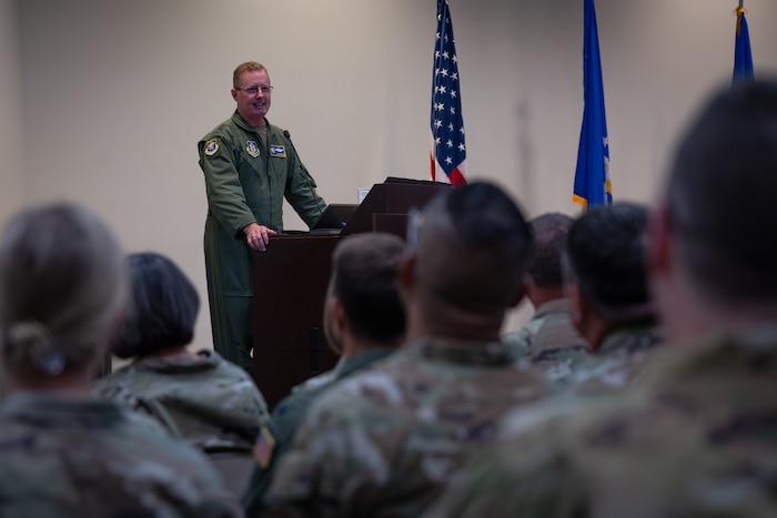 Maj. Gen. Frank Bradfield III addresses and speaks to a room filled with Airmen, family, and friends.