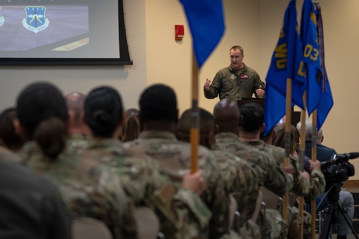 Col. Jaret Fish addresses and speaks to a room filled with Airmen, family, and friends.