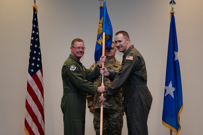 Maj. Gen. Frank Bradfield III and Col. Jaret Fish pose and hold the guidon for the 403rd Wing during an Assumption of Command ceremony.