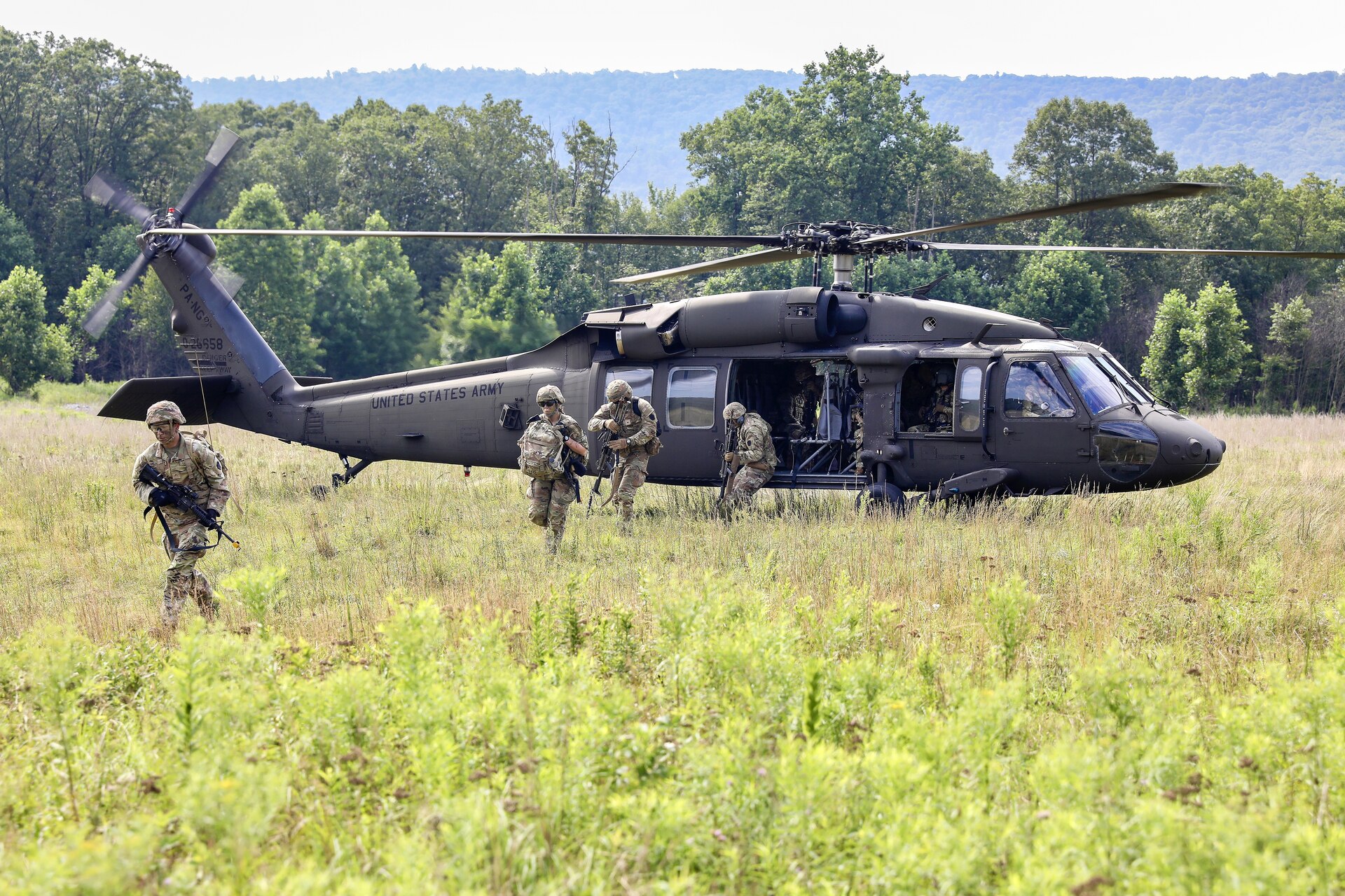 U.S. Soldiers with Charlie Company, 1st Battalion, 109th Infantry Regiment exit a UH-60 Black Hawk helicopter during an exercise at Fort Indiantown Gap, Pennsylvania, July 29, 2025. The Soldiers trained in an intensive 96 hour force-on-force exercise to simulate combat against a capable adversary. (U.S. Army National Guard photo by Staff Sgt. Zachery Jockel)