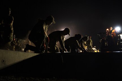 Airmen from the 157th Civil Engineer Squadron Prime Base Engineer Emergency Force smooth 250 cubic yards of concrete at the 201st Regional Training Site, Fort Indiantown Gap, Pennsylvania, July 30, 2025. Five separate sections of the CES honed their prime base engineer emergency force skills, ensuring readiness to open, sustain, and recover the base across contingency operations, emergency responses, and recovery missions. (U.S. Air National Guard photo by Tech. Sgt. Victoria Nelson)