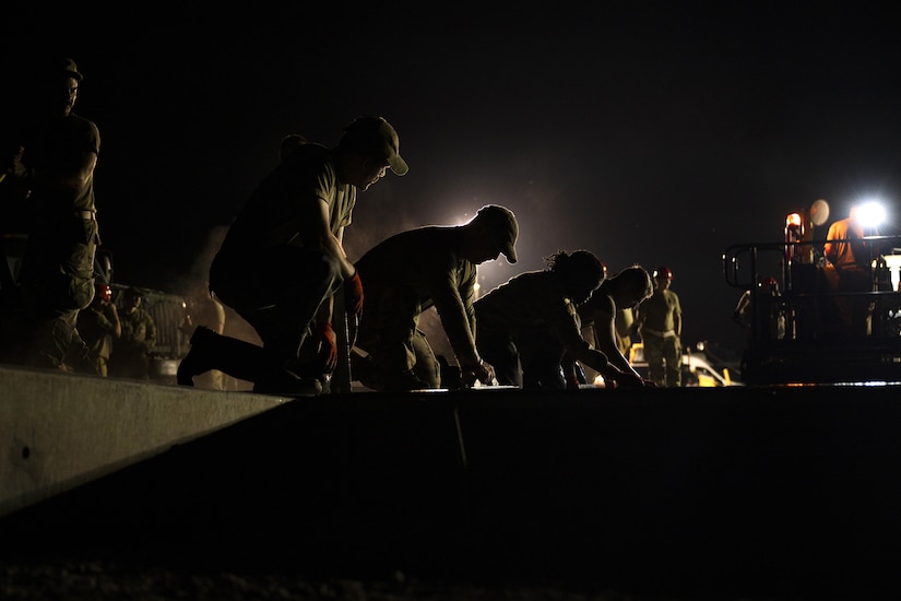 Airmen from the 157th Civil Engineer Squadron Prime Base Engineer Emergency Force smooth 250 cubic yards of concrete at the 201st Regional Training Site, Fort Indiantown Gap, Pennsylvania, July 30, 2025. Five separate sections of the CES honed their prime base engineer emergency force skills, ensuring readiness to open, sustain, and recover the base across contingency operations, emergency responses, and recovery missions. (U.S. Air National Guard photo by Tech. Sgt. Victoria Nelson)