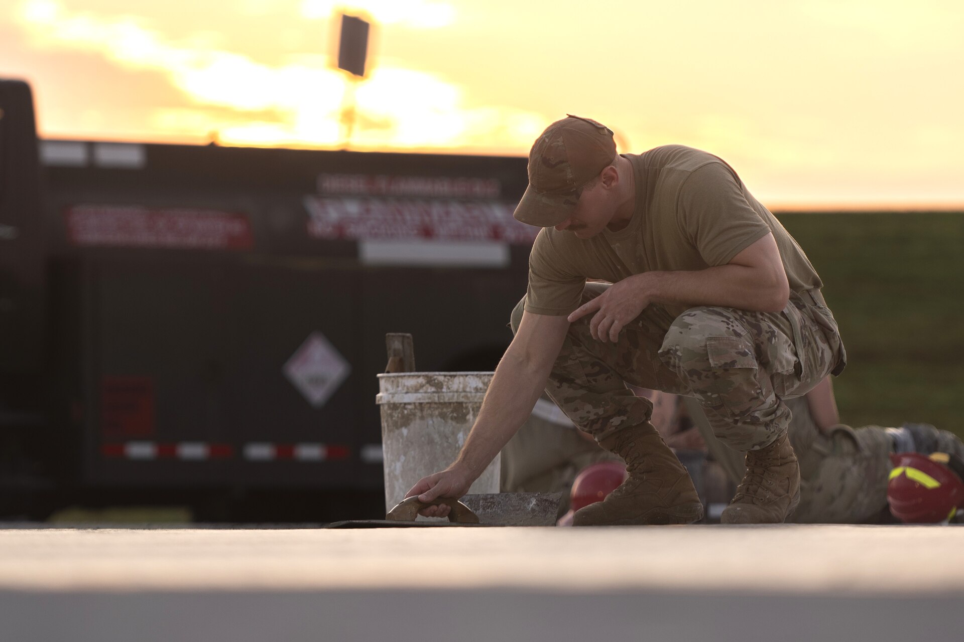 Tech. Sgt. Alan Bauman, the structures NCO in charge with the 157th Civil Engineer Squadron, smooths concrete as the sun rises at the 201st Regional Training Site, Fort Indiantown Gap, Pennsylvania, July 30, 2025. The team of engineers constructed a new runway from the ground up and worked as a team alongside Airmen from the 219th CES, Montana Air National Guard. (U.S. Air National Guard photo by Tech. Sgt. Victoria Nelson)