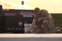 Tech. Sgt. Alan Bauman, the structures NCO in charge with the 157th Civil Engineer Squadron, smooths concrete as the sun rises at the 201st Regional Training Site, Fort Indiantown Gap, Pennsylvania, July 30, 2025. The team of engineers constructed a new runway from the ground up and worked as a team alongside Airmen from the 219th CES, Montana Air National Guard. (U.S. Air National Guard photo by Tech. Sgt. Victoria Nelson)
