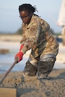 Airman 1st Class Deborah Wembabazi, a heavy equipment specialist with the 157th Civil Engineer Squadron, levels concrete during a prime base engineer emergency force training at the 201st Regional Training Site, Fort Indiantown Gap, Pennsylvania, July 30, 2025. The engineers poured concrete and constructed an expeditionary runway while honing Prime BEEF processes and skill sets. (U.S. Air National Guard photo by Tech. Sgt. Victoria Nelson)