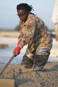 Airman 1st Class Deborah Wembabazi, a heavy equipment specialist with the 157th Civil Engineer Squadron, levels concrete during a prime base engineer emergency force training at the 201st Regional Training Site, Fort Indiantown Gap, Pennsylvania, July 30, 2025. The engineers poured concrete and constructed an expeditionary runway while honing Prime BEEF processes and skill sets. (U.S. Air National Guard photo by Tech. Sgt. Victoria Nelson)