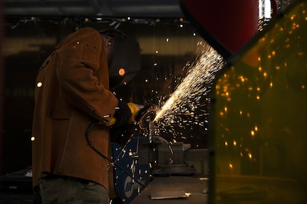 Tech. Sgt. Alan Bauman, structures NCO in charge with the 157th Civil Engineer Squadron, grinds a metal plate during a weeklong base engineer emergency force training at the 201st Regional Training Site, Fort Indiantown Gap, Pennsylvania, Aug. 1, 2025. The prime BEEF training sharpened expeditionary engineering skills in high-heat conditions, reinforcing mission readiness for rapid deployment environments. (U.S. Air National Guard photo by Tech. Sgt. Victoria Nelson)