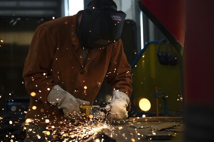Senior Airman Collin Small, a structures specialist with the 157th Civil Engineer Squadron, grinds a metal plate during a week-long prime base engineer emergency force training at Fort Indiantown Gap, Pennsylvania, Aug. 1, 2025. The prime BEEF training sharpened expeditionary engineering skills in high-heat conditions, reinforcing mission readiness for rapid deployment environments. (U.S. Air National Guard photo by Tech. Sgt. Victoria Nelson)