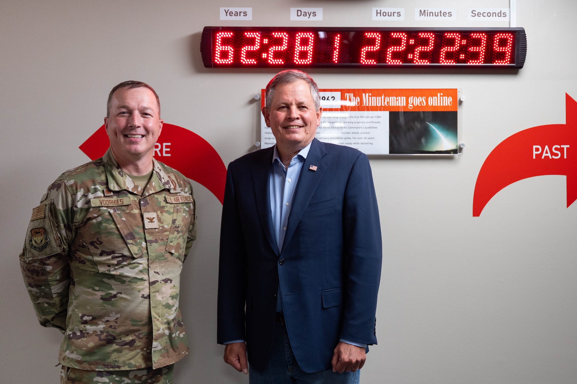 A man stands next to a man in uniform.