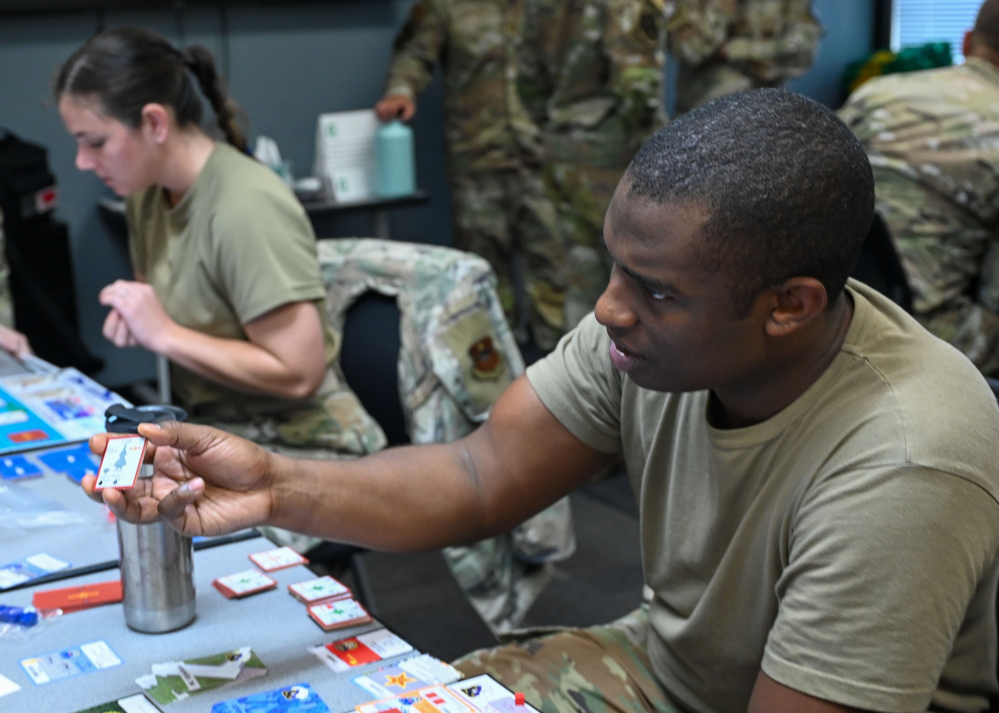 U.S. Air Force Maj. Quinton Kennedy, 30th Student Squadron, Squadron Officer School flight commander and instructor, shows a card to his opponent in an Air Force Wargame Indo-Pacific exercise at Maxwell Air Force Base, Alabama, July 22, 2025.