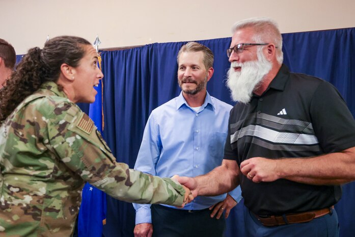 U.S. Air Force Major Jennifer Young, 9 Force Support Squadron commander, left, shakes hands with Nicholas “Willie” Whittlesey, center, and Rob Gregor, after the Honorary Commander program induction ceremony at Beale Air Force Base, California, August 1, 2025.
