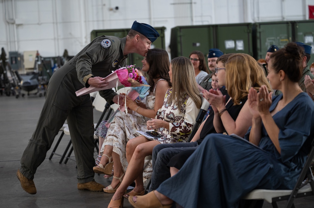 U.S. Air Force Col. Curtis Dougherty, left, 354th Operations Group outgoing commander, gives flowers to his family at Eielson Air Force Base, Alaska, Aug. 5, 2025.