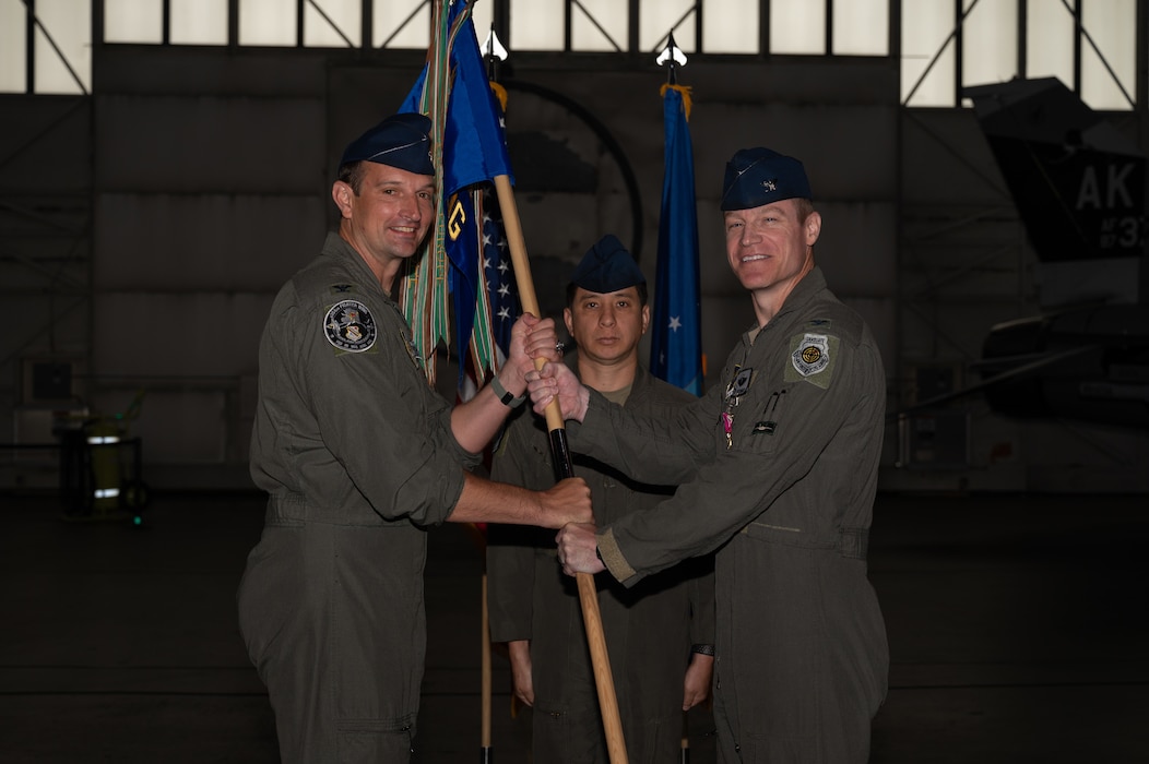U.S. Air Force Col. Curtis Dougherty, right, 354th Operations Group outgoing commander, relinquishes the guidon to Col. Matthew Johnston, 354th Fighter Wing commander, during a change of command ceremony at Eielson Air Force Base, Alaska, Aug. 5, 2025
