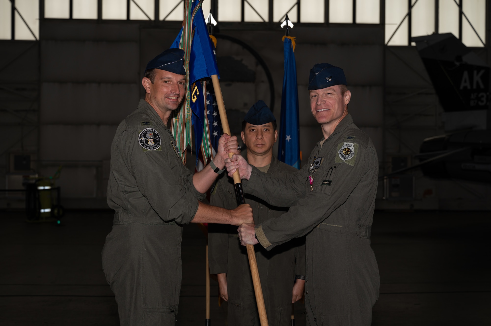 U.S. Air Force Col. Curtis Dougherty, right, 354th Operations Group outgoing commander, relinquishes the guidon to Col. Matthew Johnston, 354th Fighter Wing commander, during a change of command ceremony at Eielson Air Force Base, Alaska, Aug. 5, 2025