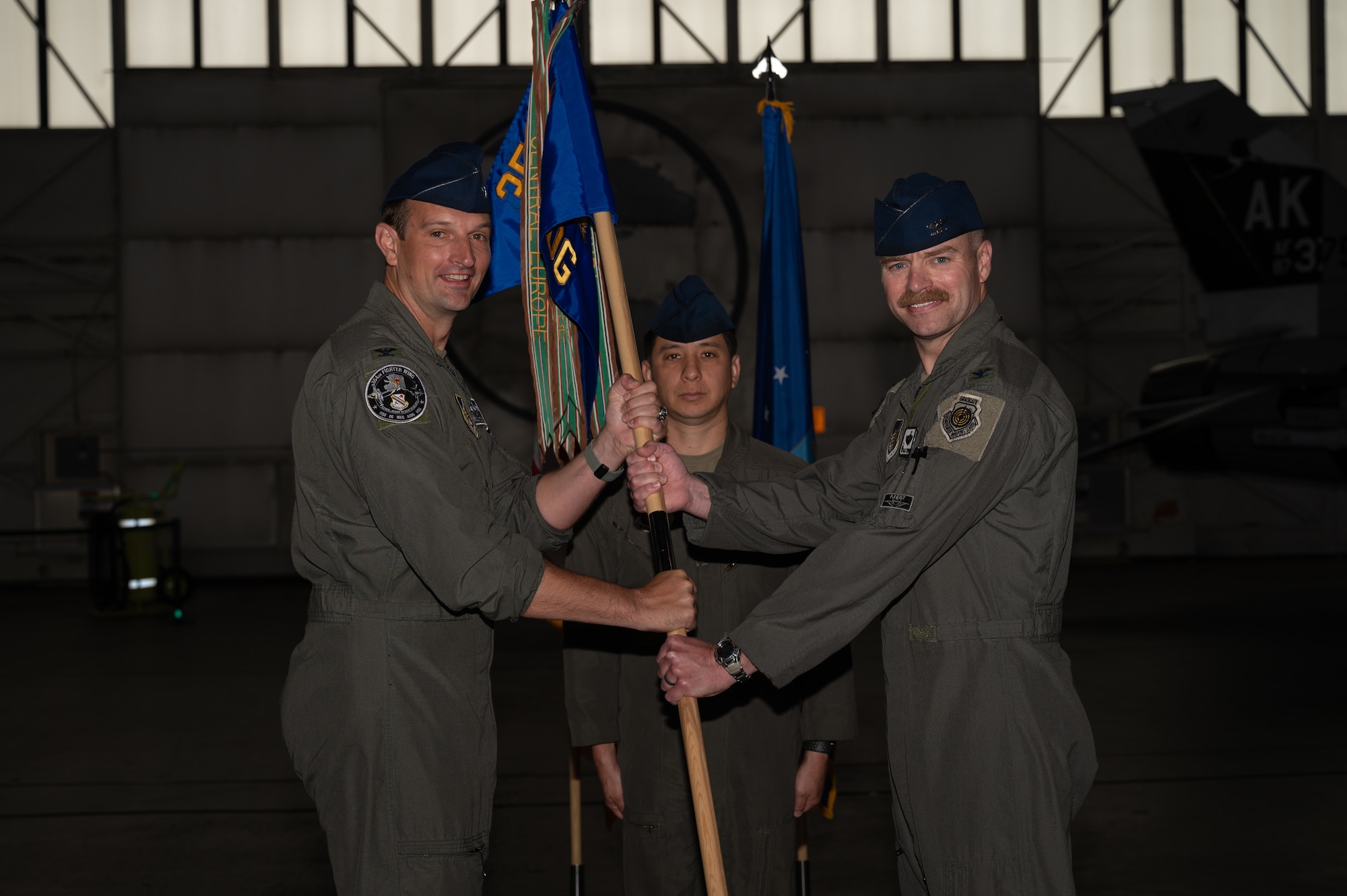 U.S. Air Force Col. Matthew Johnston, 354th Fighter Wing commander, passes the guidon to Col. Samuel Chipman, 354th Operations Group incoming commander, during a change of command ceremony at Eielson Air Force Base, Alaska, Aug. 5, 2025.