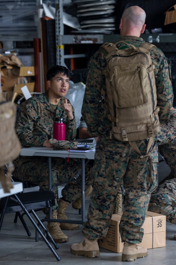 U.S. Marine Corps Lance Cpl. Jeremiah Botello checks in a U.S. Navy Sailor during an Alert Contingency Marine Air Ground Task Force (ACM) drill on Camp Courtney, Okinawa, Japan, July 15, 2025. The ACM exercise is a simulated crisis response drill that must be executed within 24 hours to prepare Marines to mitigate emergencies, provide humanitarian aid, or counter threats to U.S. national interests within the Indo-Pacific region. Botello, a native of Texas, is a logistics specialist with 3D Marine Expeditionary Brigade. (U.S. Marine Corps photo by Lance Cpl. Jeffrey Pruett)