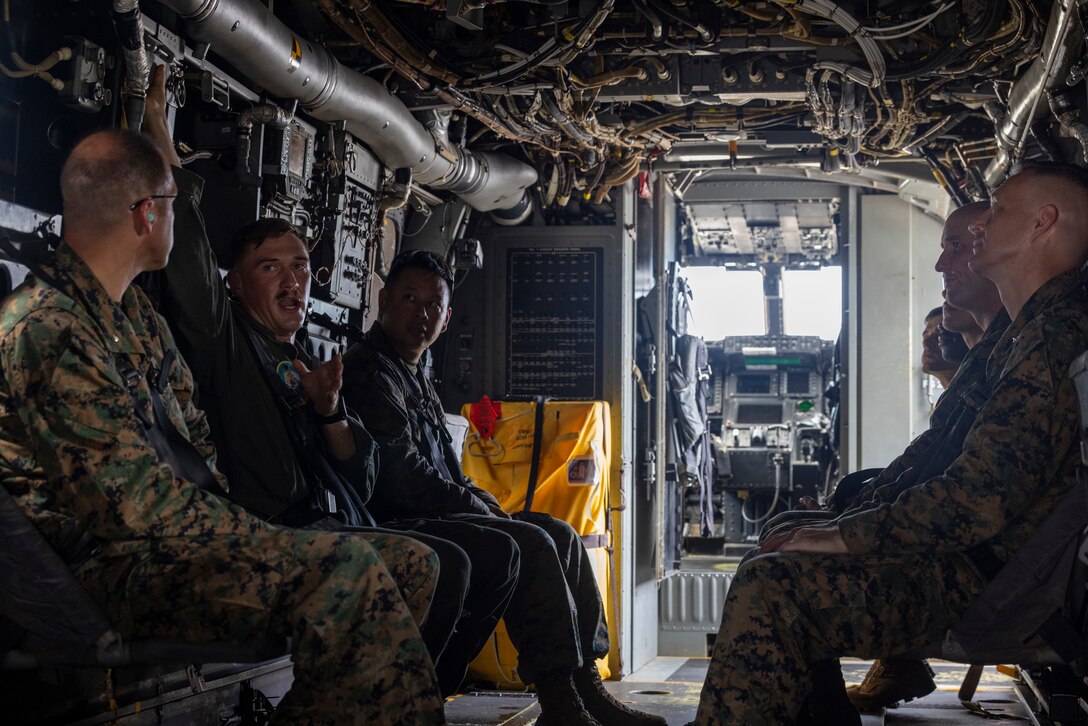 U.S. Marine Corps Sgt. Jarett Legg explains the egress procedures for the MV-22 Osprey during an Alert Contingency Marine Air Ground Task Force (ACM) drill on Marine Corps Air Station Futenma, Okinawa, Japan, July 15, 2025. The ACM exercise is a simulated crisis response drill that must be executed within 24 hours to prepare Marines to mitigate emergencies, provide humanitarian aid, or counter threats to U.S. national interests within the Indo-Pacific region. Legg, a native of Vermont, is an MV-22 tiltrotor mechanic with 1st Marine Aircraft Wing. (U.S. Marine Corps photo by Lance Cpl. Jeffrey Pruett)